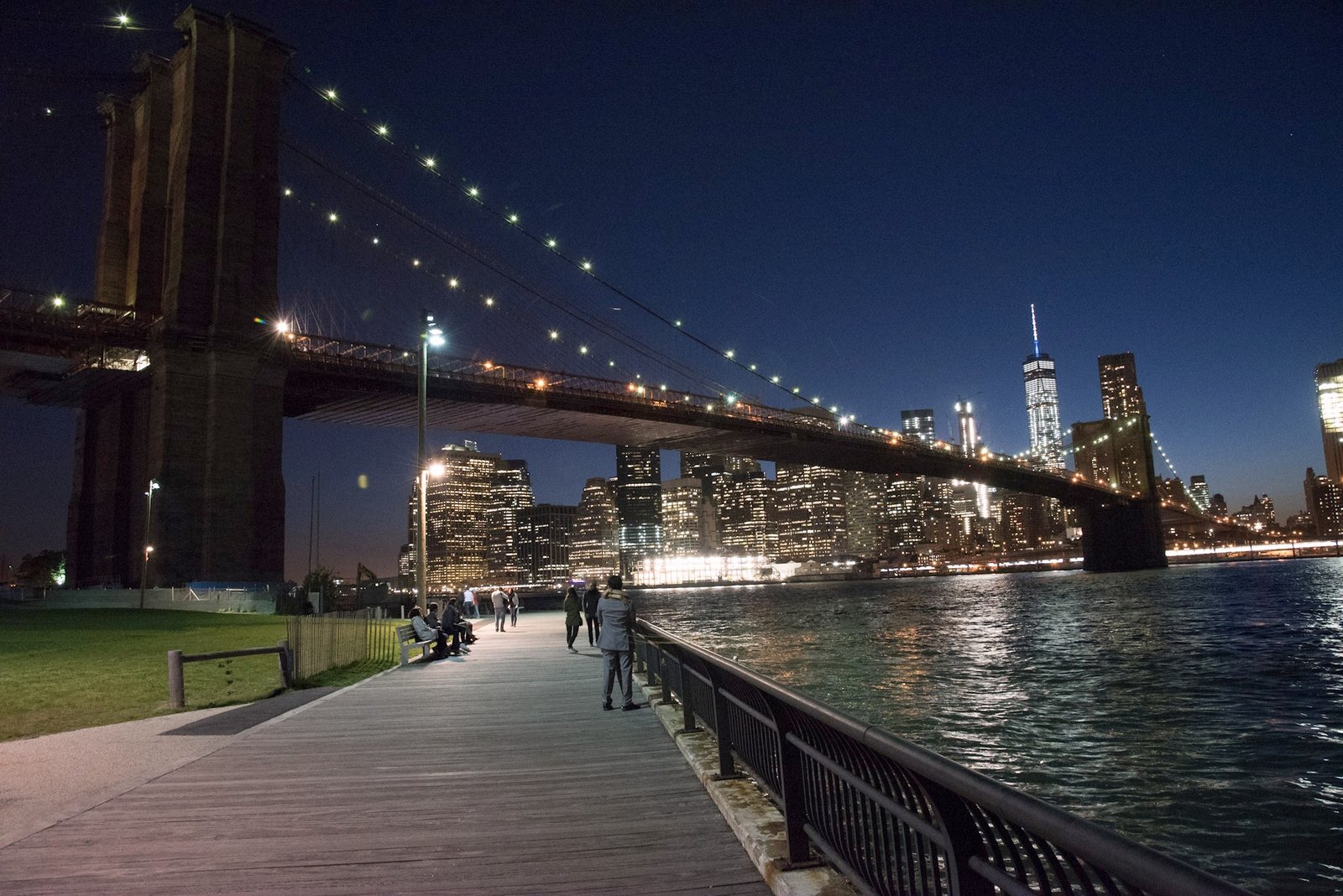 Brooklyn waterfront boardwalk and Manhattan lights after dark.