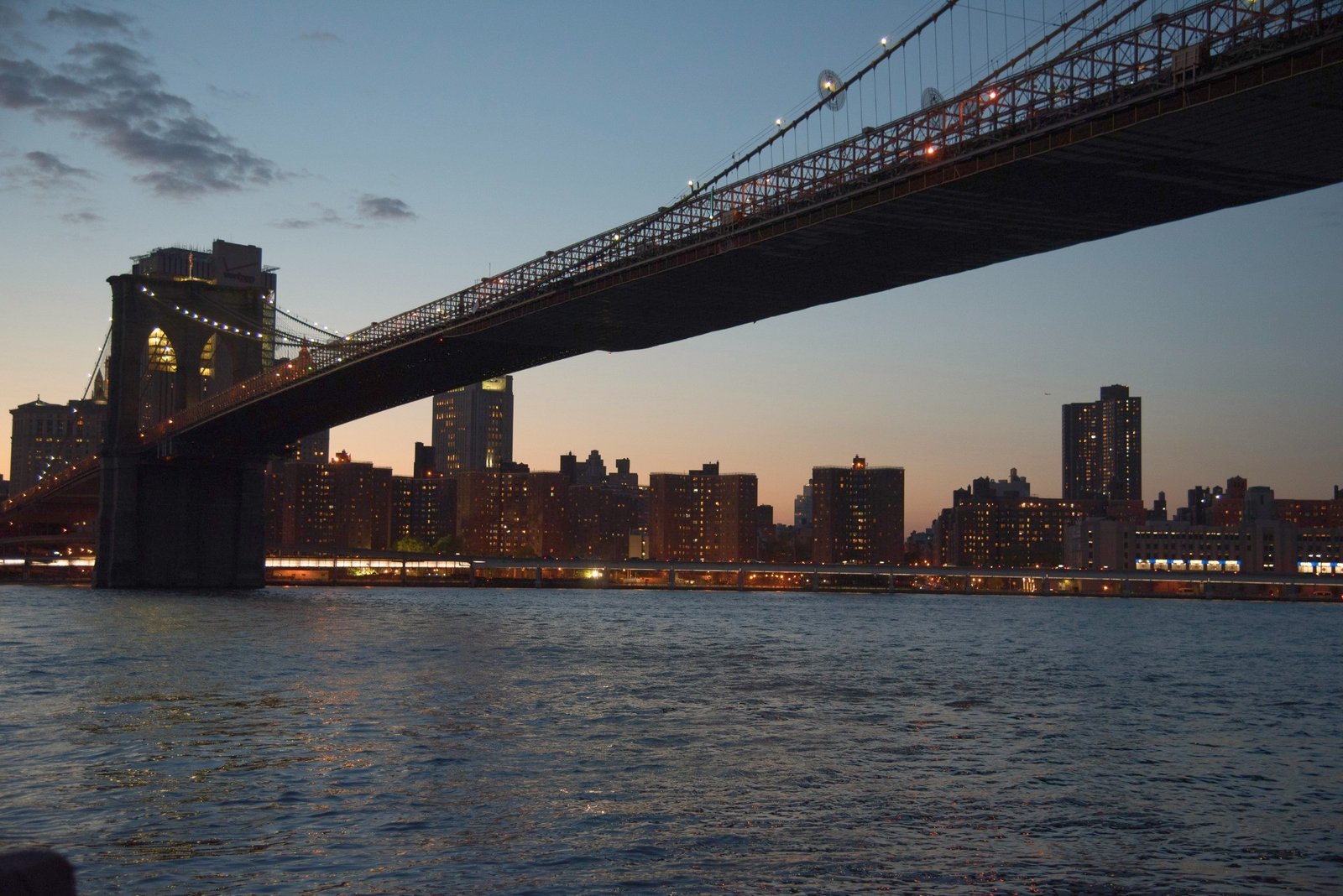 Brooklyn Bridge above the East River at dusk.